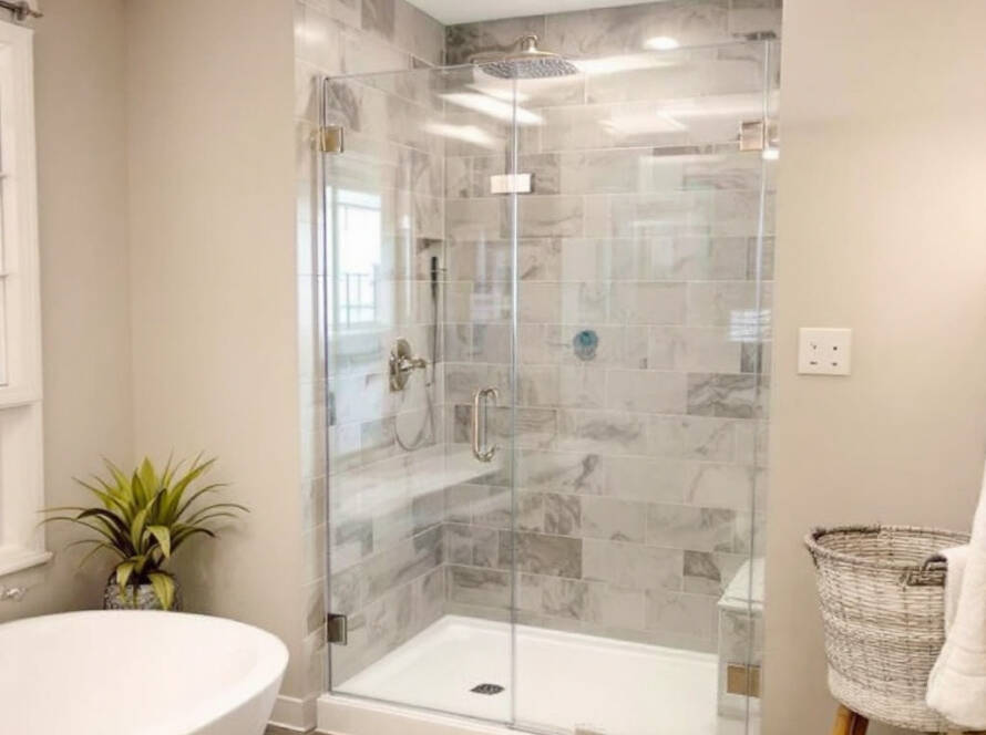 Skilled worker installing a pristine shower door in a modern, contemporary bathroom in Allston, MA.