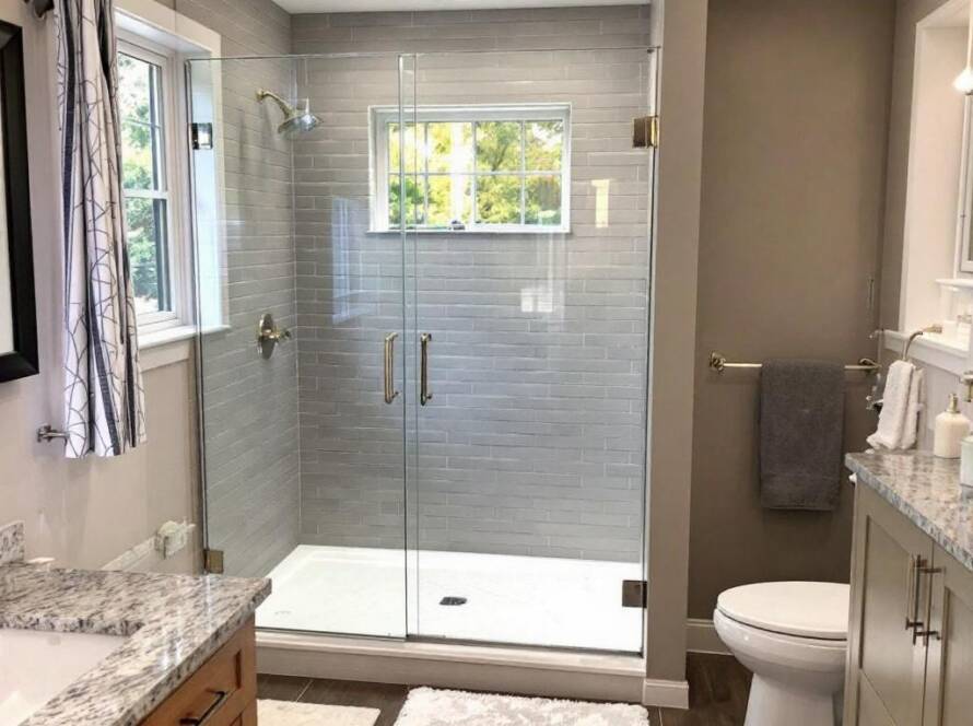 An industry expert demonstrating the installation of a pre purchased modern shower door in a Boston home, following a contemporary design.