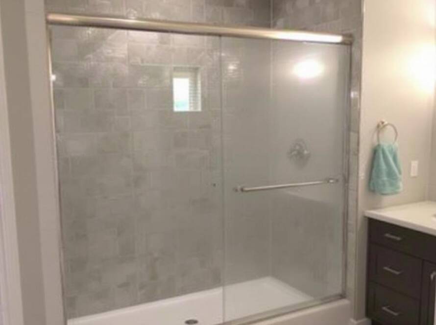 Custom frameless shower doors in a modern and contemporary designed bathroom.