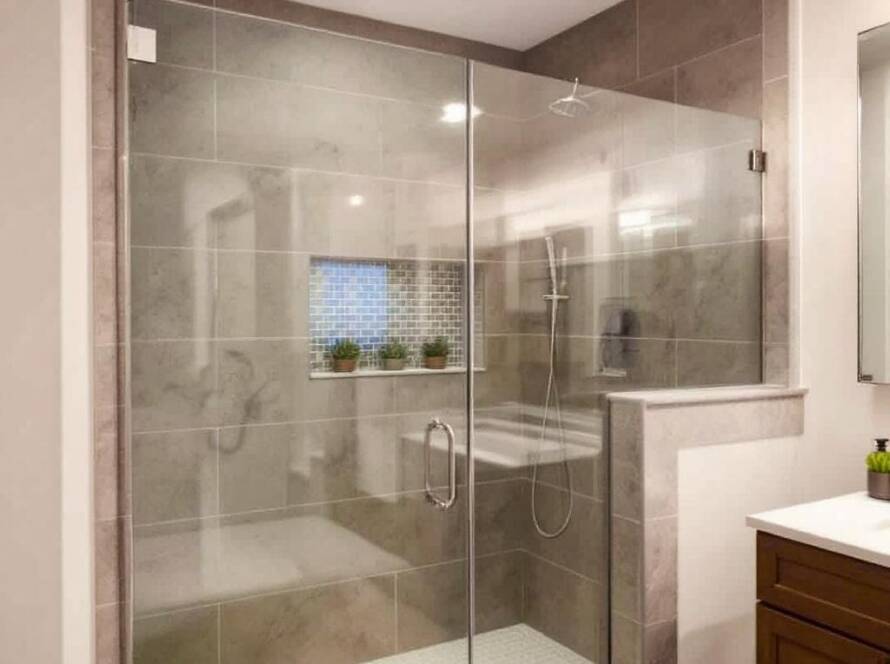 A professional replacing a modern glass shower door in a contemporary washroom near Lynn.